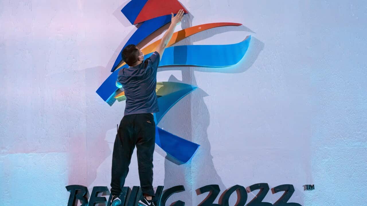 A crew member leaps to fix a logo for the 2022 Beijing Winter Olympics in Beijing.