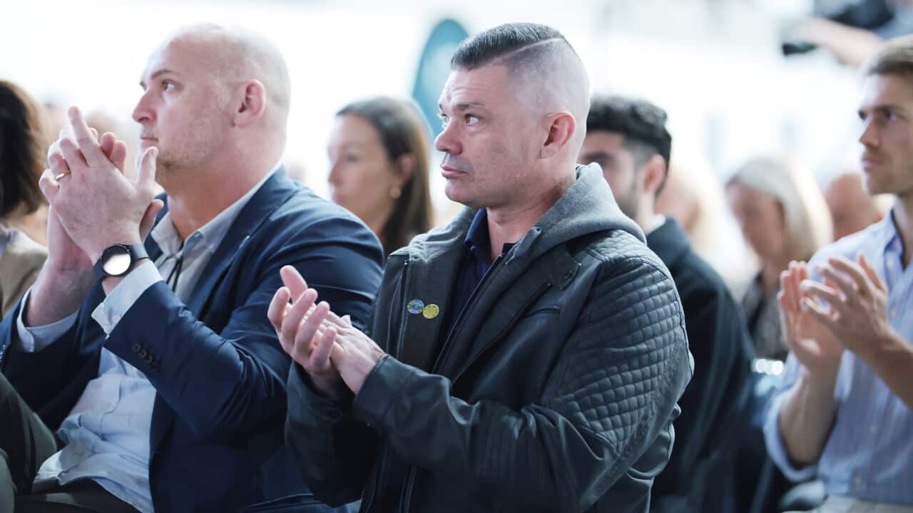 A man claps in a crowd