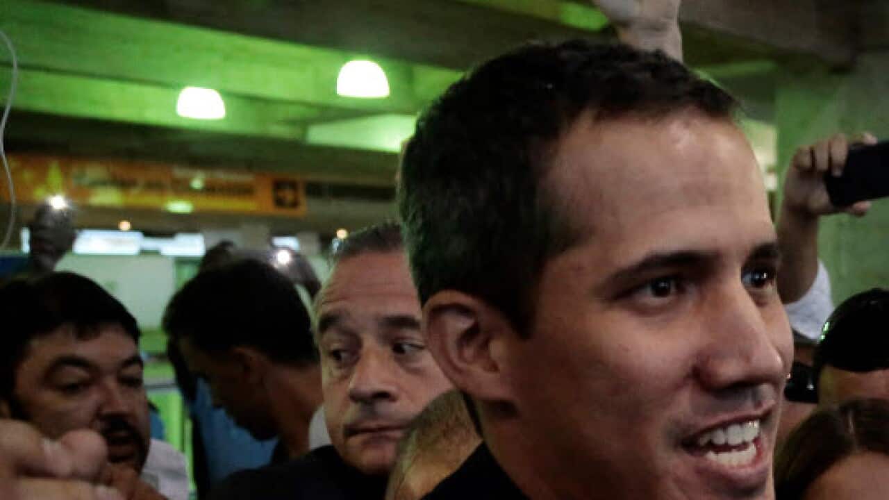 President of the Venezuelan National Assembly, Juan Guaido (C), addresses the media upon his arrival (AAP)