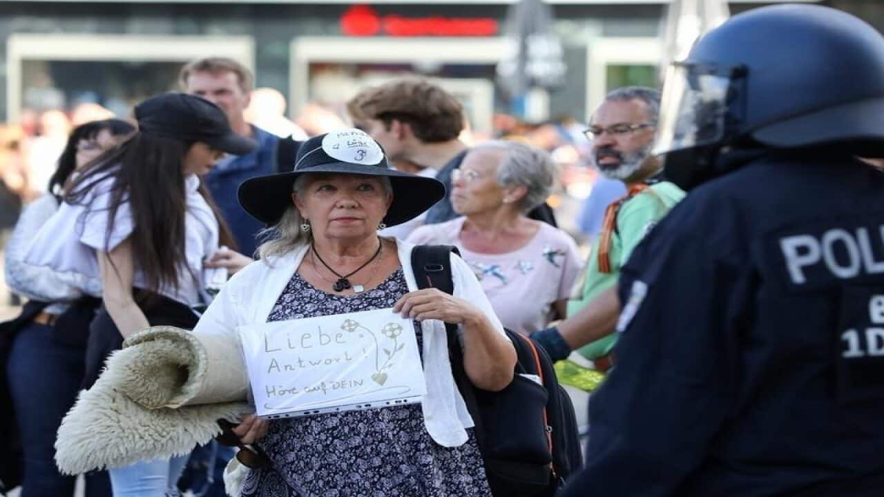 A woman holds a sign reading: "Love is the answer" in Germany