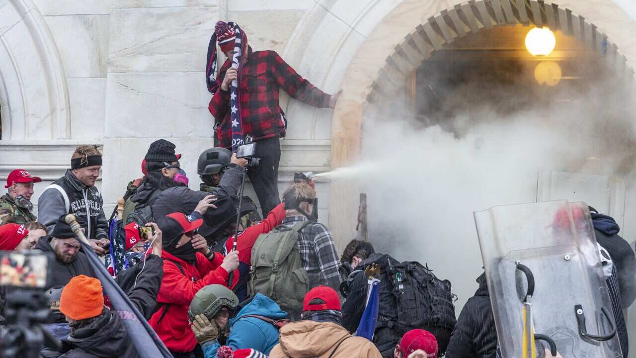 Rioters use tear gas while clashing with police trying to