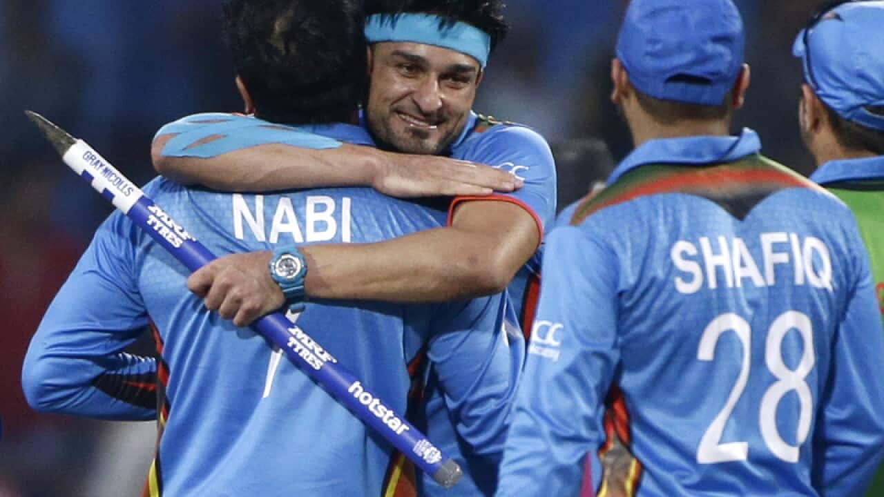 Afghanistan’s Hamid Hassan, facing camera, hugs teammate Mohammad Nabi
