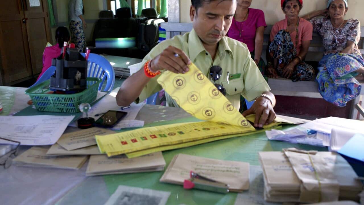A staff member of the election commission prepares ballot at a polling station in the WaiMaw township of the MaKhanDi village, Kachin State