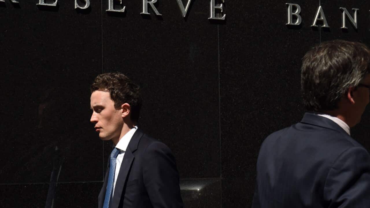 A pedestrian walks past the Reserve Bank of Australia in Sydney