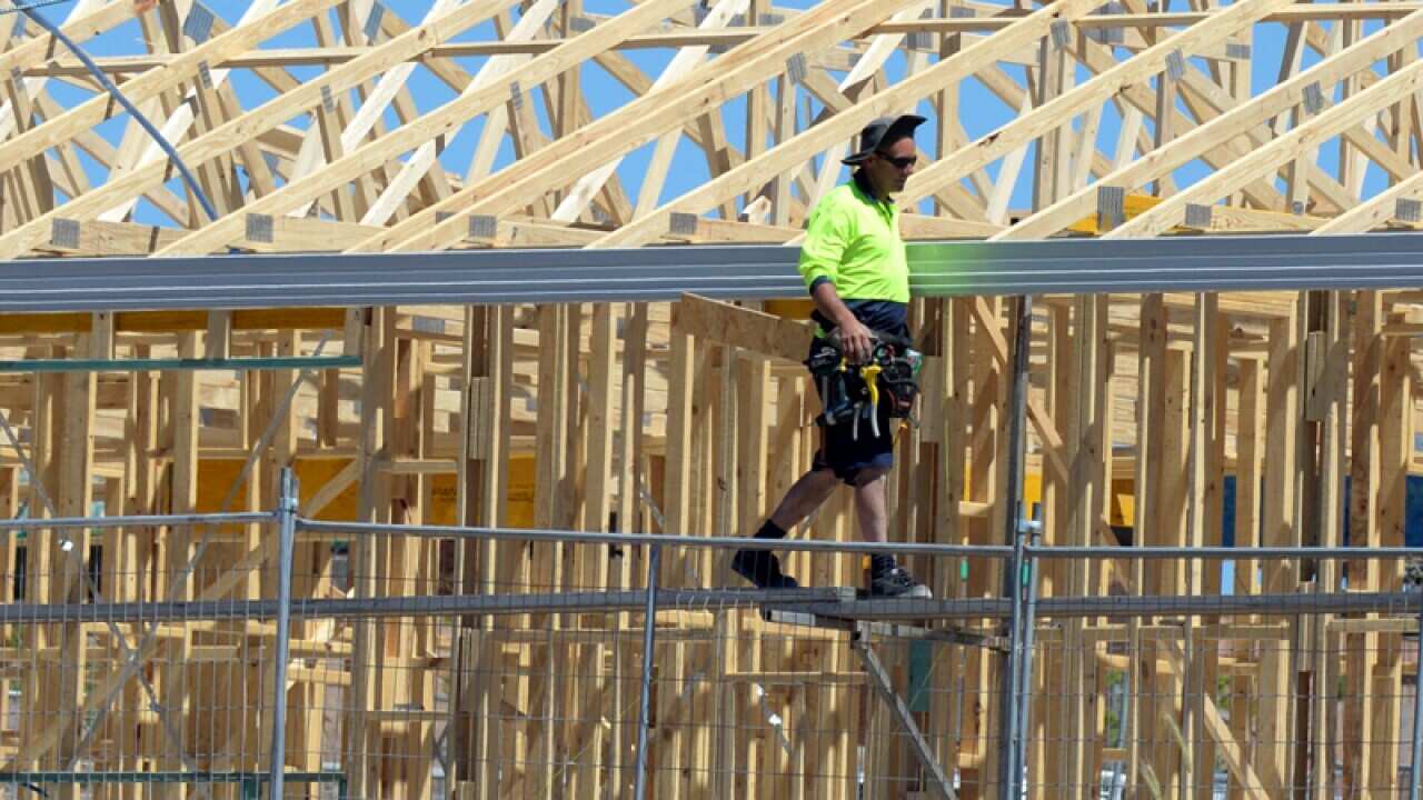 A tradesman works on housing construction.