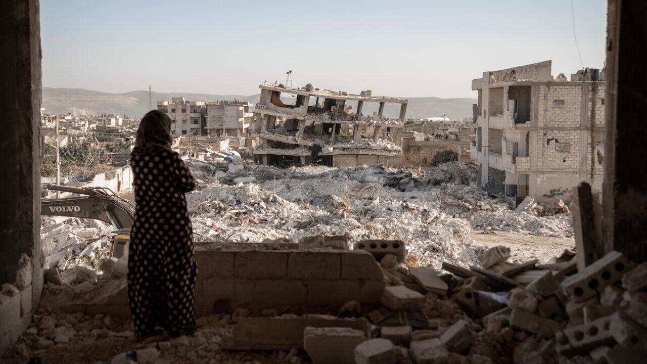 Jinderis, Syria - A woman looks over a scene of destruction foll
