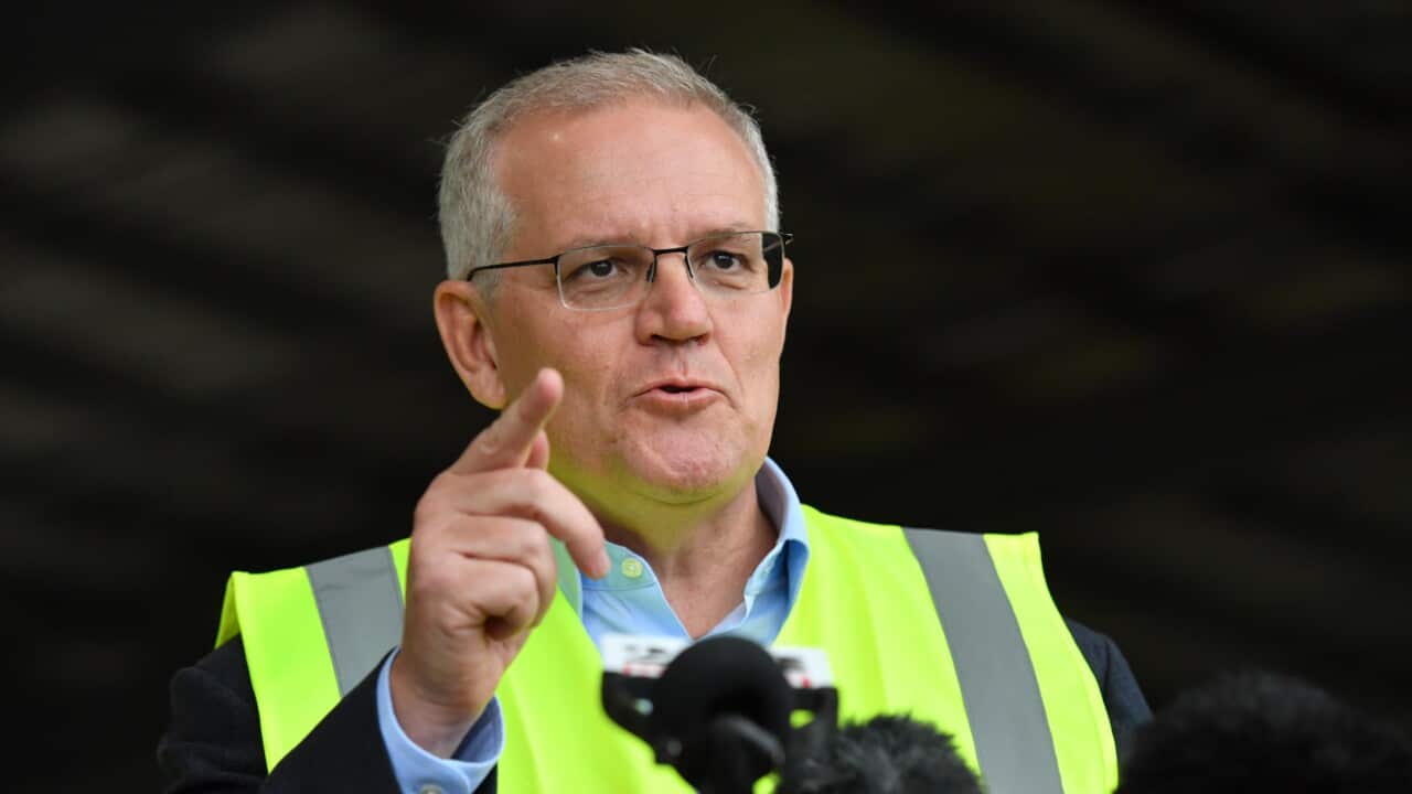 Prime Minister Scott Morrison wears a yellow hi-viz vest with his finger pointed, speaking at a press conference.