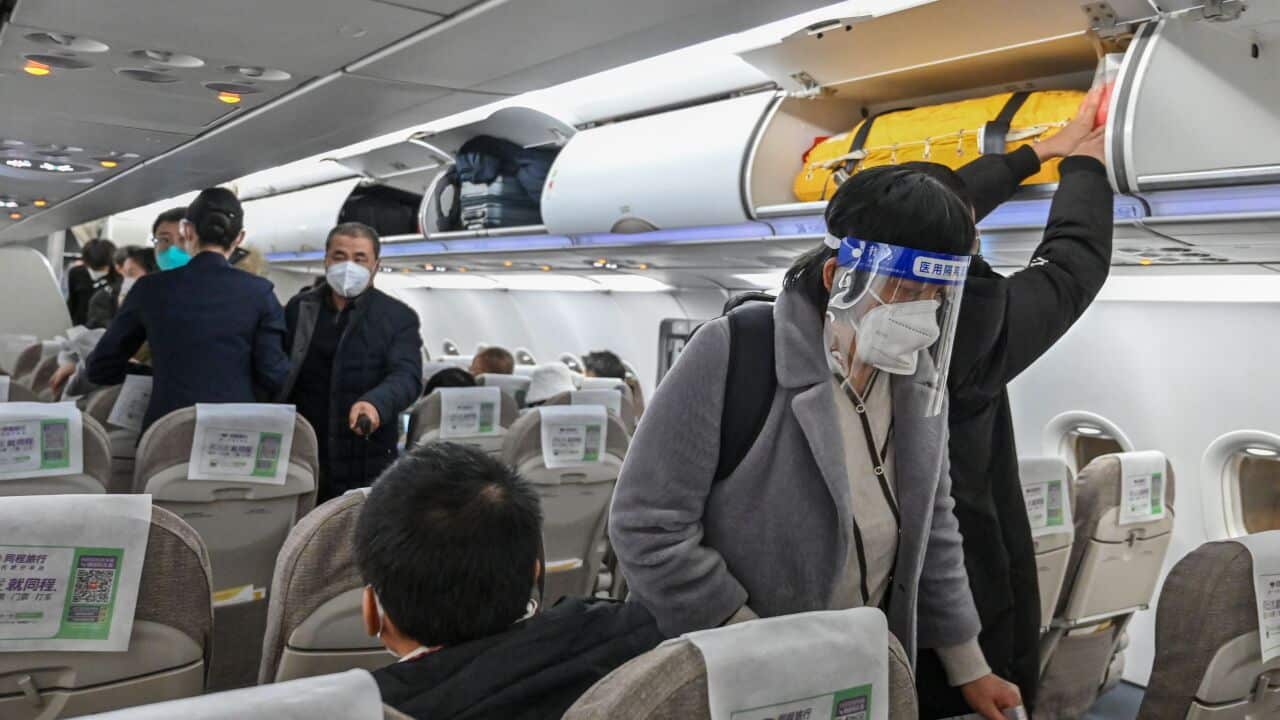 Passengers wearing face masks board a flight in Shanghai