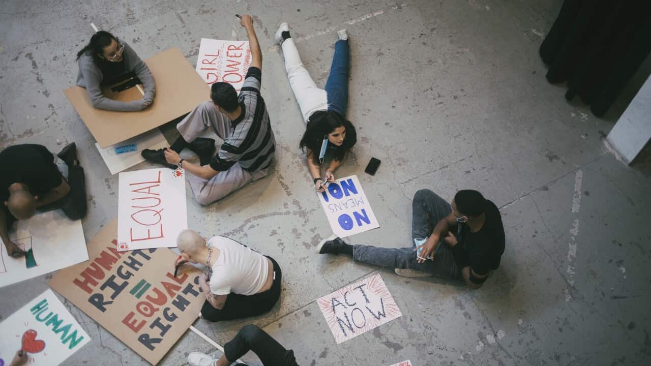 High angle view of female and male protestor preparing signboards for human rights