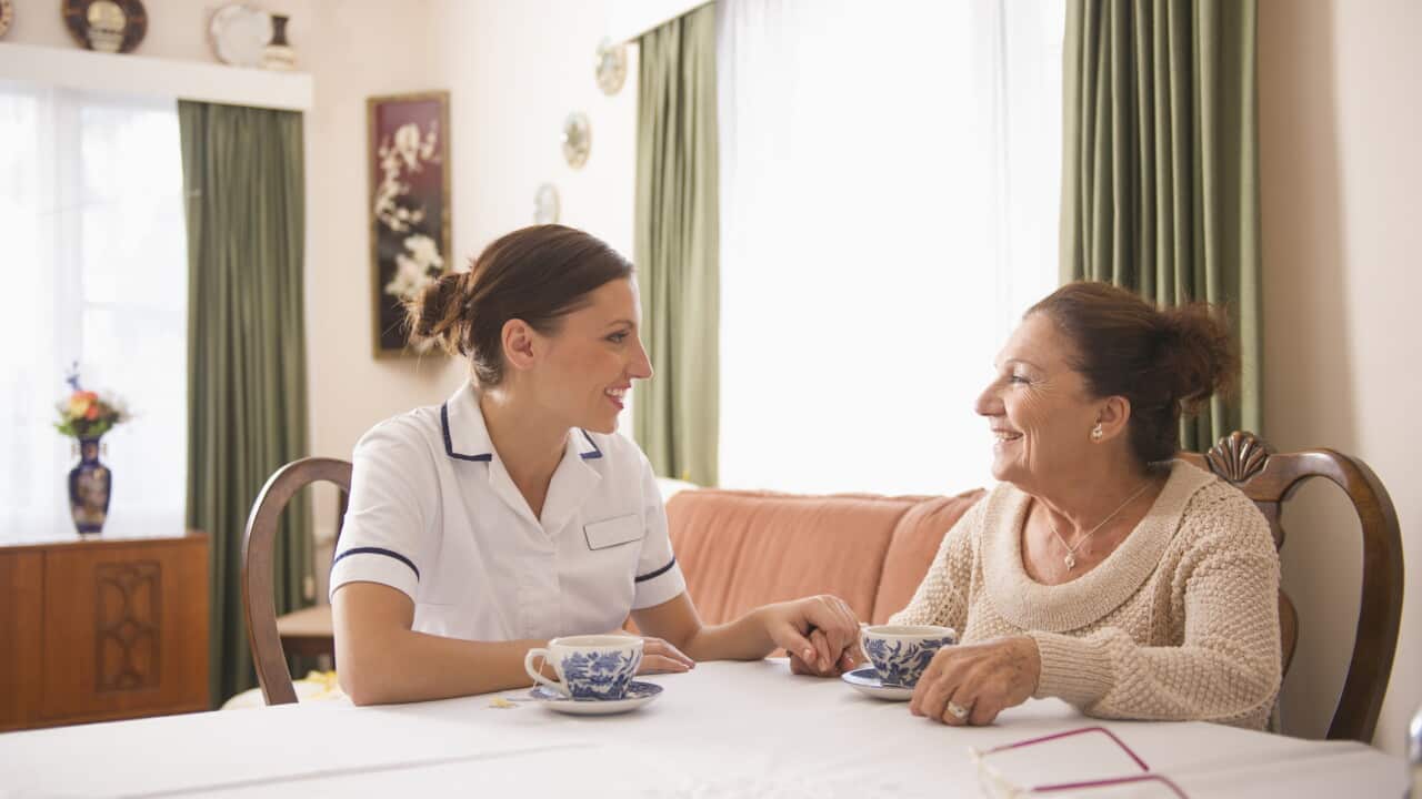 Hispanic nurse talking to senior woman