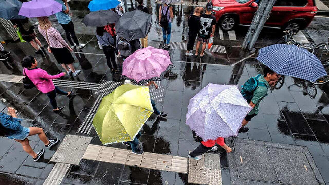 People walk in the rain in the CBD, in Melbourne