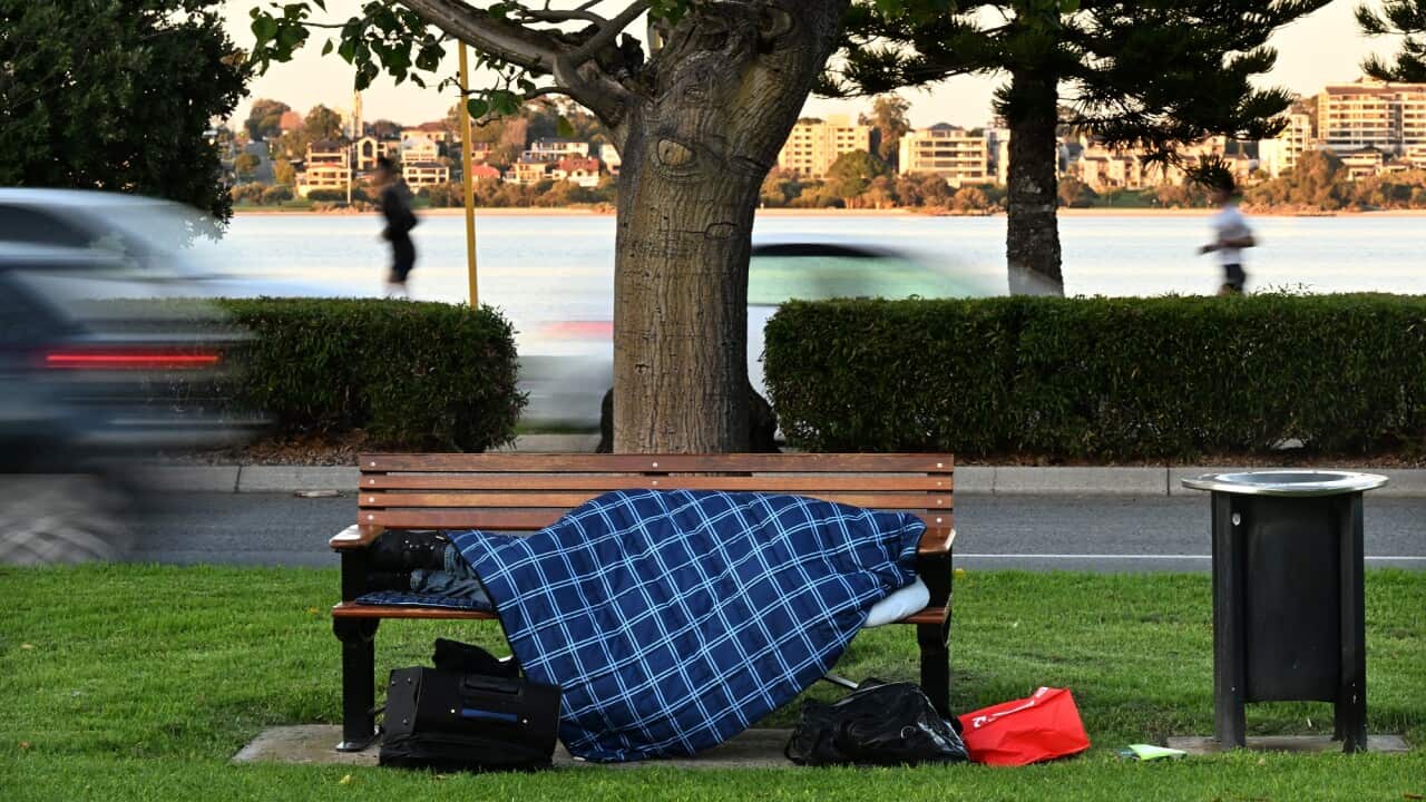 A homeless person is seen sleeping on a park bench in Perth.