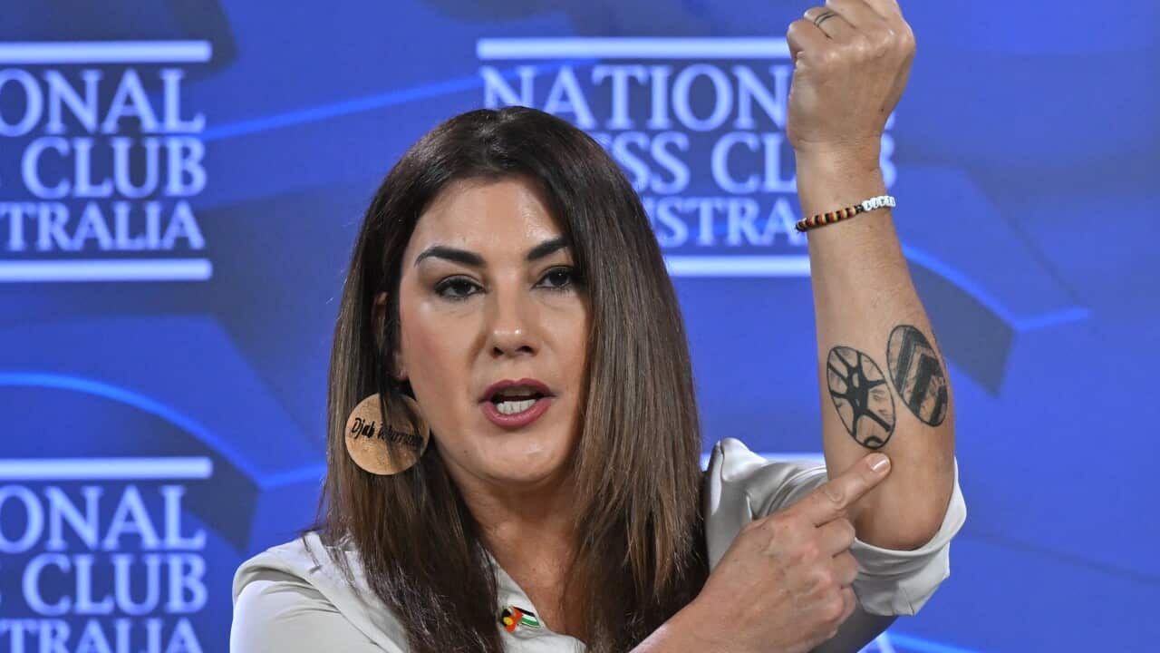 Woman points to tattoos on her arm.