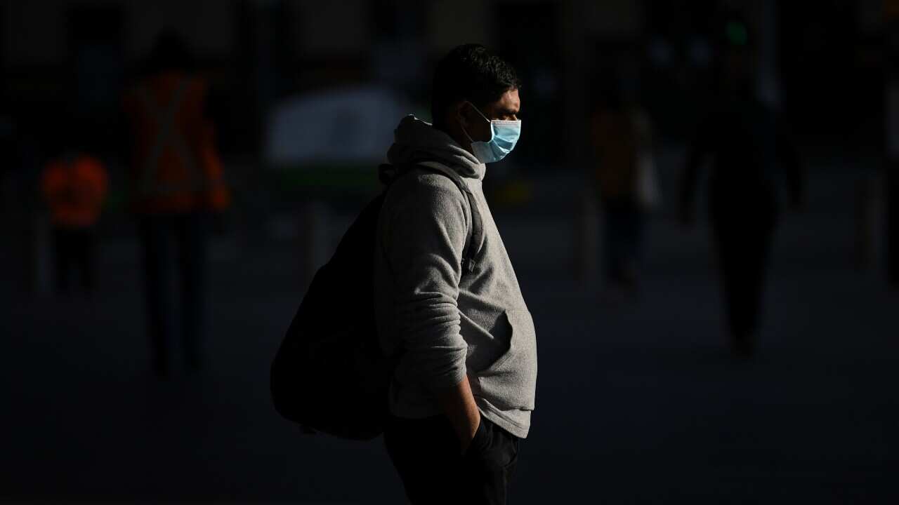 A man wearing a face mask is seen outside Flinders Street Station in Melbourne as the city emerges from lockdown.
