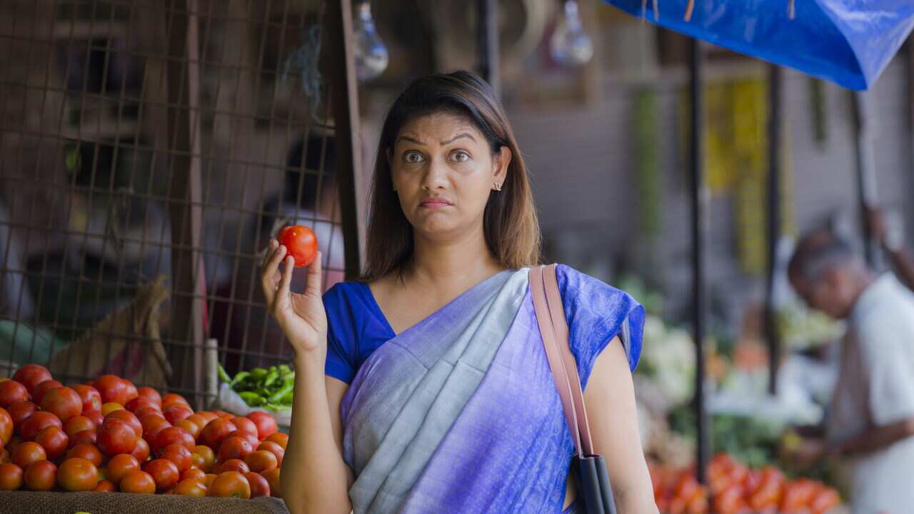 Woman buying vegetables at a street vendor. stock photo