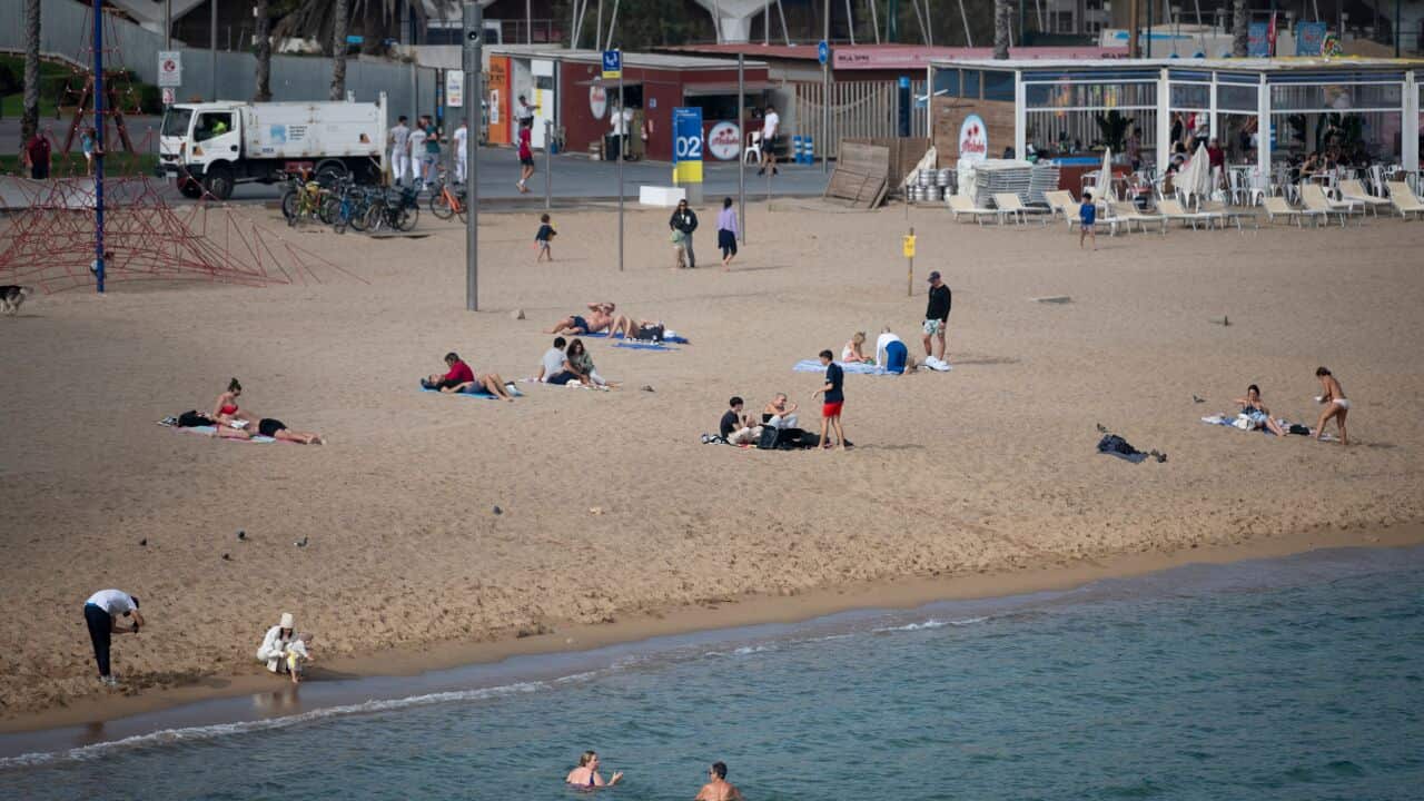 Swimmers at a Barcelona beach where late October temperatures are more like midsummer than autumn
