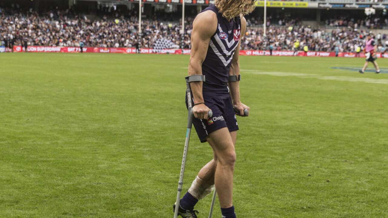 Fremantle midfielder Nat Fyfe limps off the field