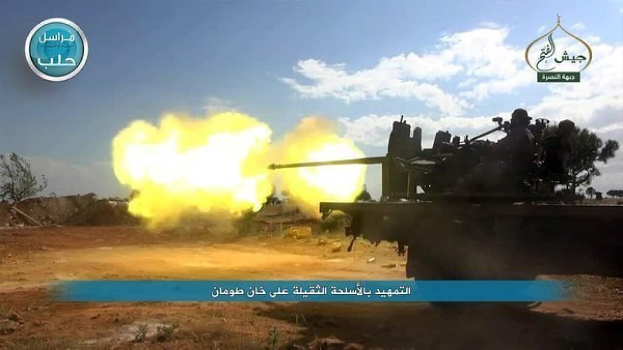 A fighter from the Nusra Front firing a weapon during clashes against Syrian government forces in the town of Khan Touman, near Aleppo province