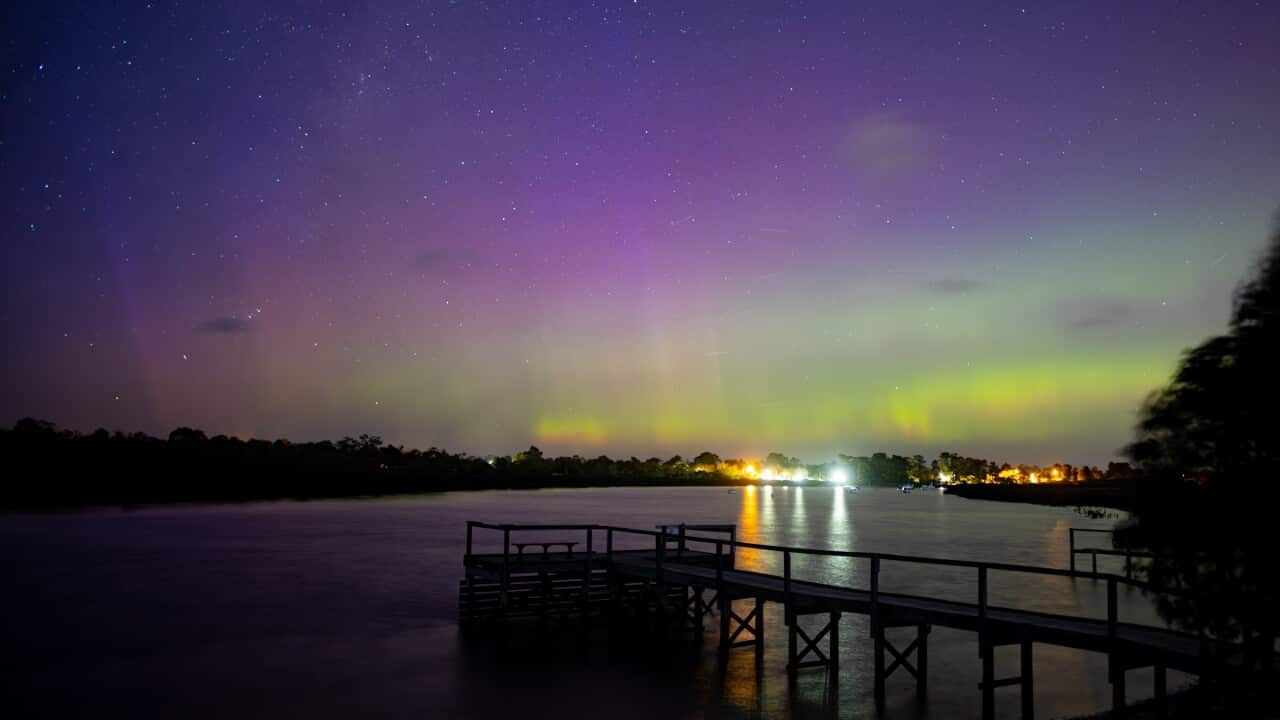 Sky lit up with green and purple aurora lights.
