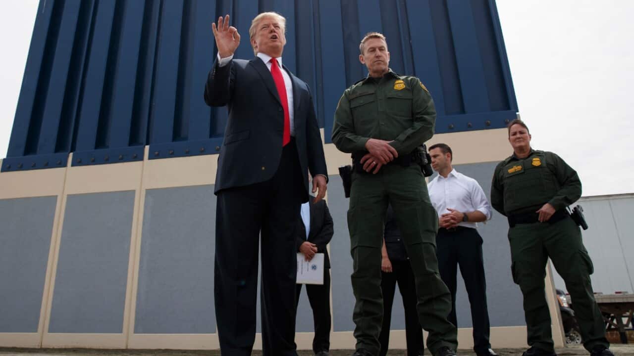 In this March 13, 2018 file photo, President Donald Trump talks with reporters as he reviews border wall prototypes in San Diego.