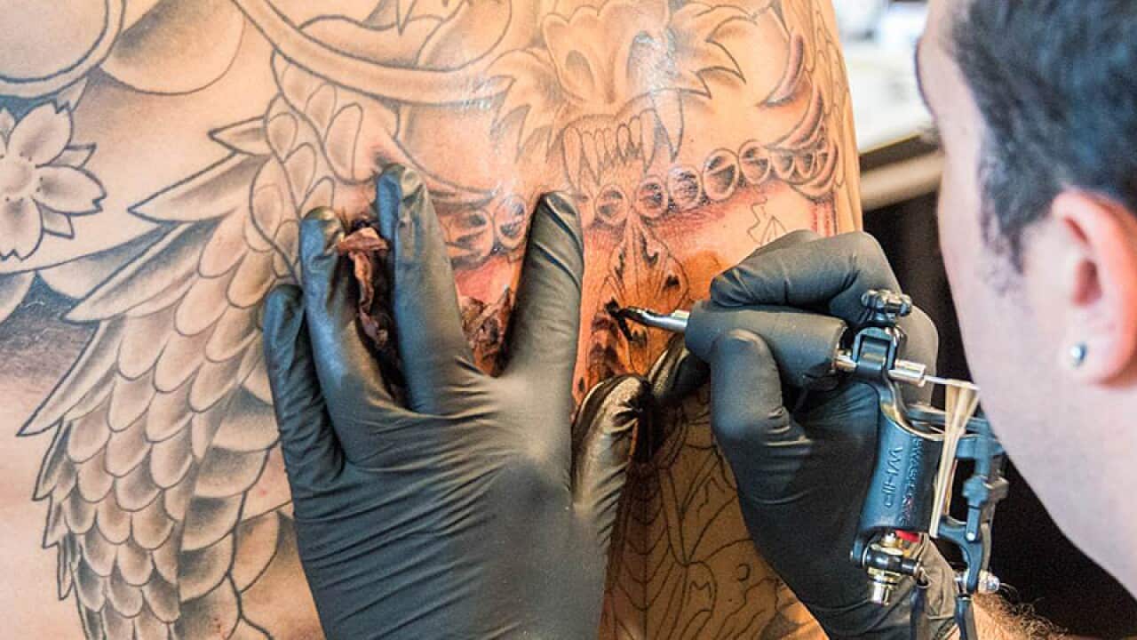 Tattoo artists at work at the Australian Tattoo & Body Art Expo.