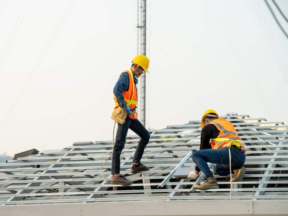 Two roofers inspecting new roof.