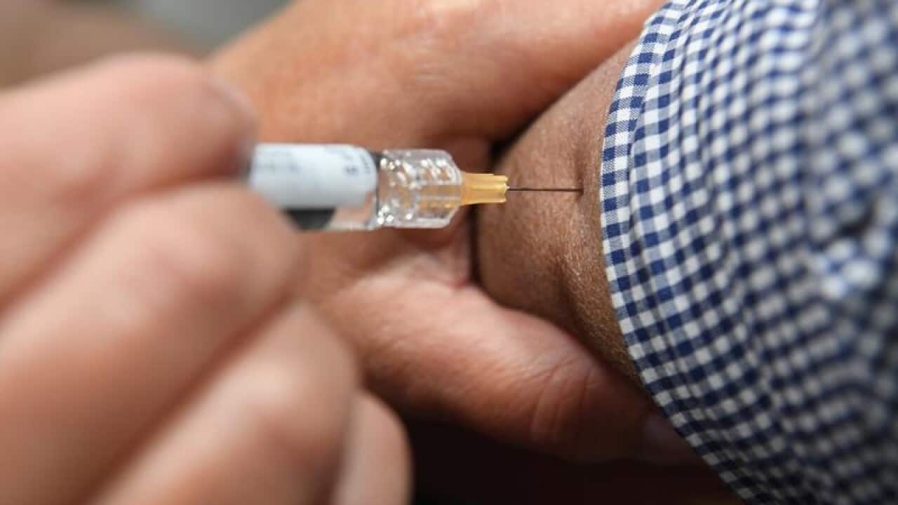 A man is seen receiving a flu immunisation shot
