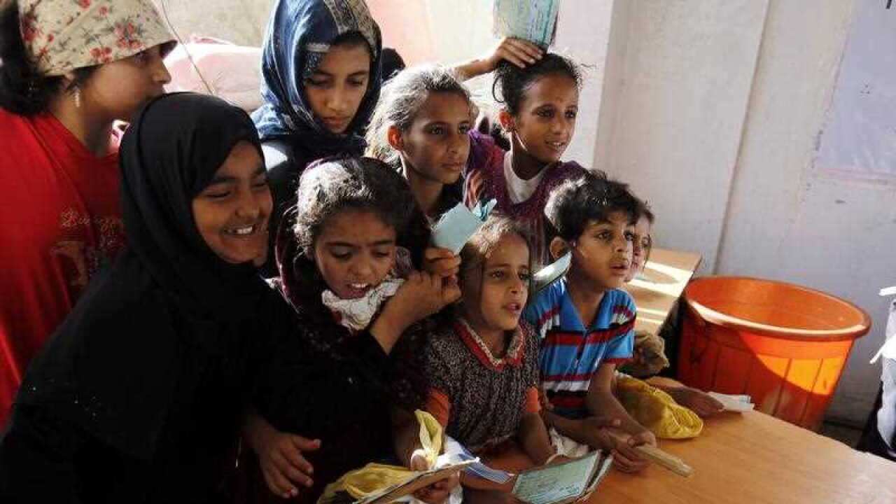 Conflict-affected Yemenis children wait to receive free foods