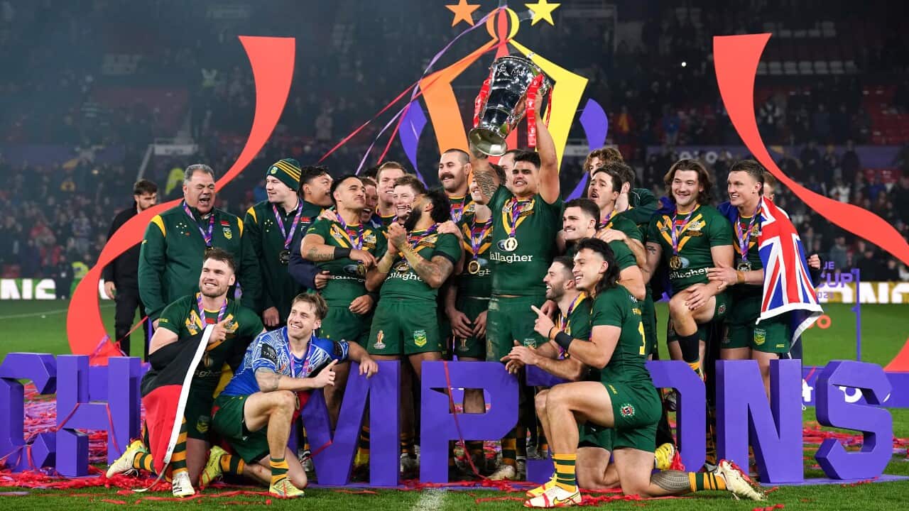Australia's men's rugby team hold up the World Cup trophy