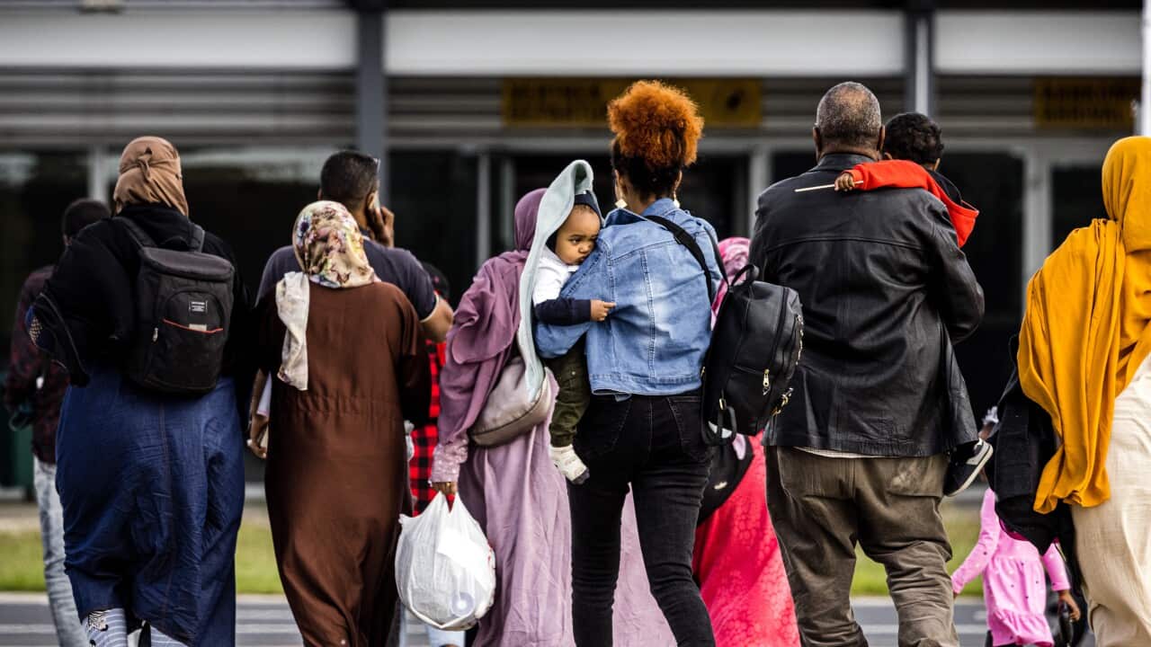 People walk across an airport tarmac