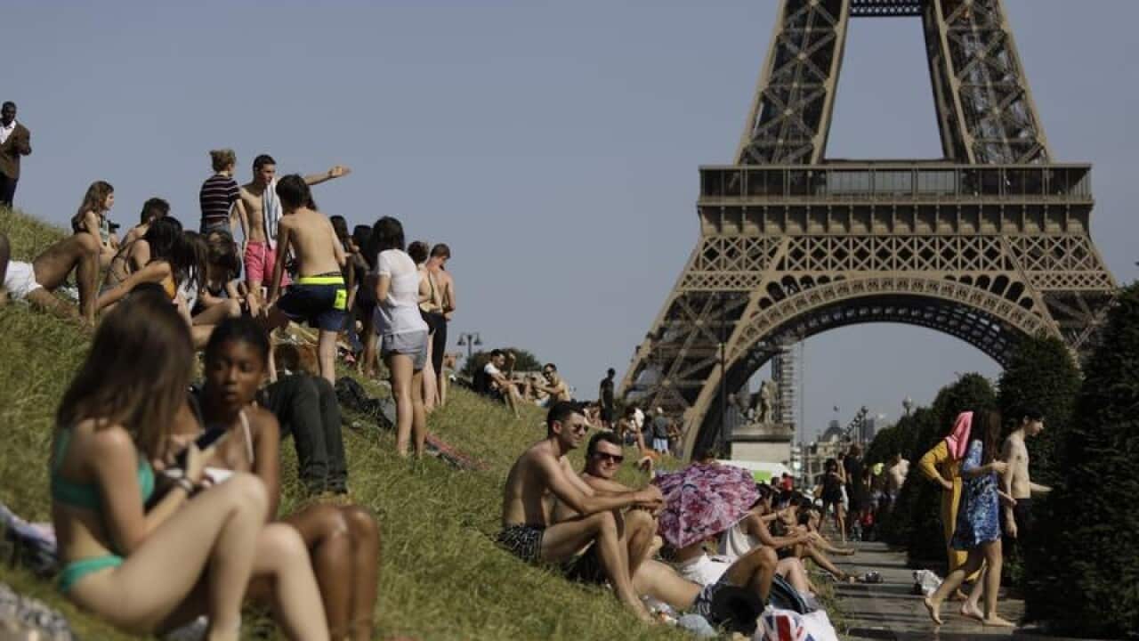People enjoy the sun in the Trocadero Gardens in Paris