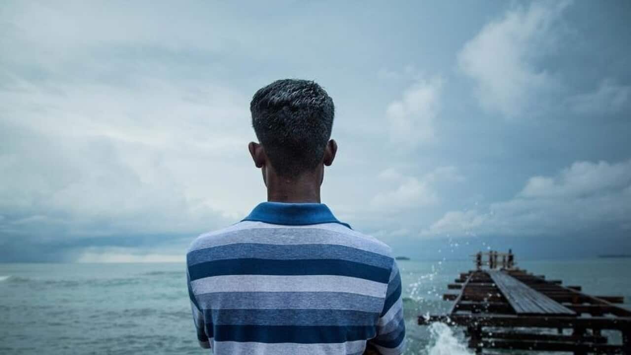A supplied image of a refugee looking out to the sea on Manus Island.