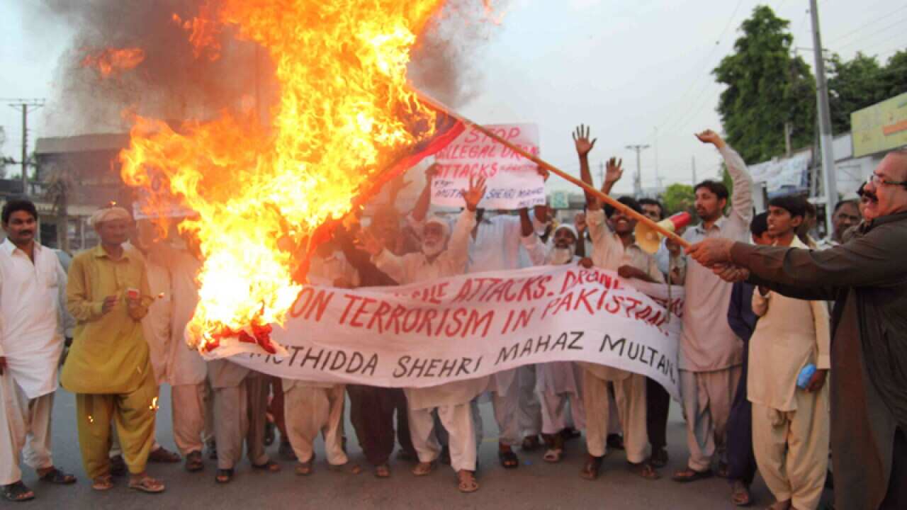 Pakistan activist burn a US flag during protests against drone strikes