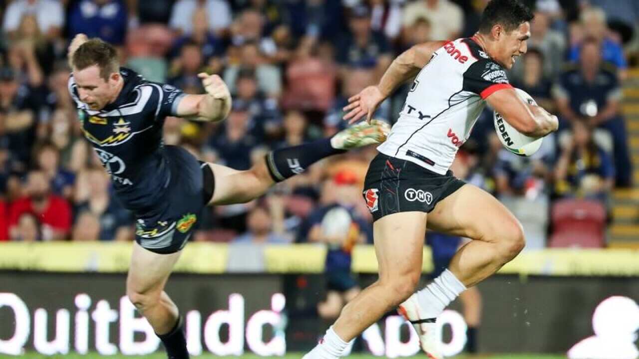 The Warriors Roger Tuivasa-Sheck, makes his way past Michael Morgan.