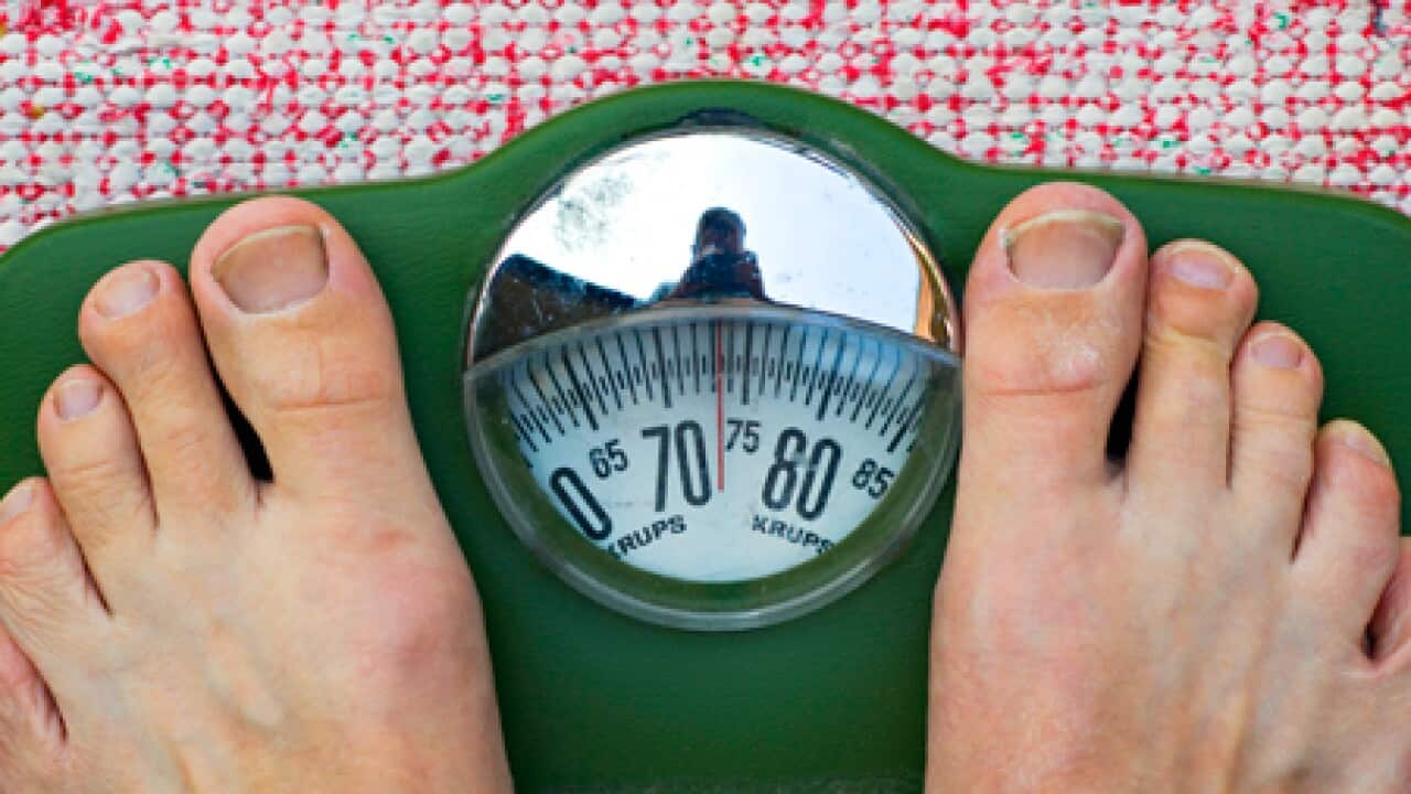 A person stands on a weighing scale