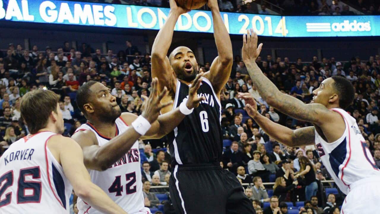 Brooklyn Nets player Alan Anderson (C) attempts a shot