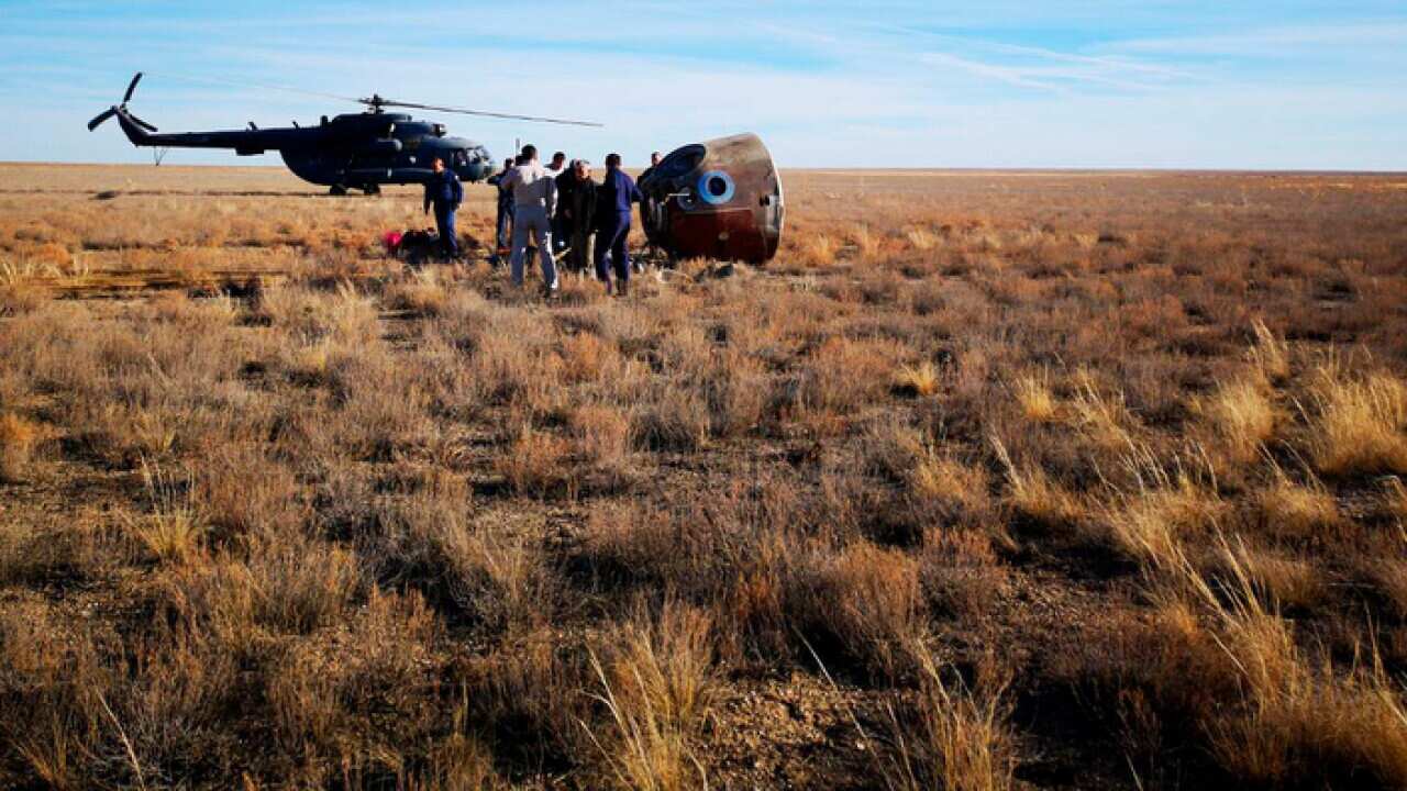 The rescue team next to the Soyuz MS-10 space capsule after it made an emergency landing in Kazakhstan