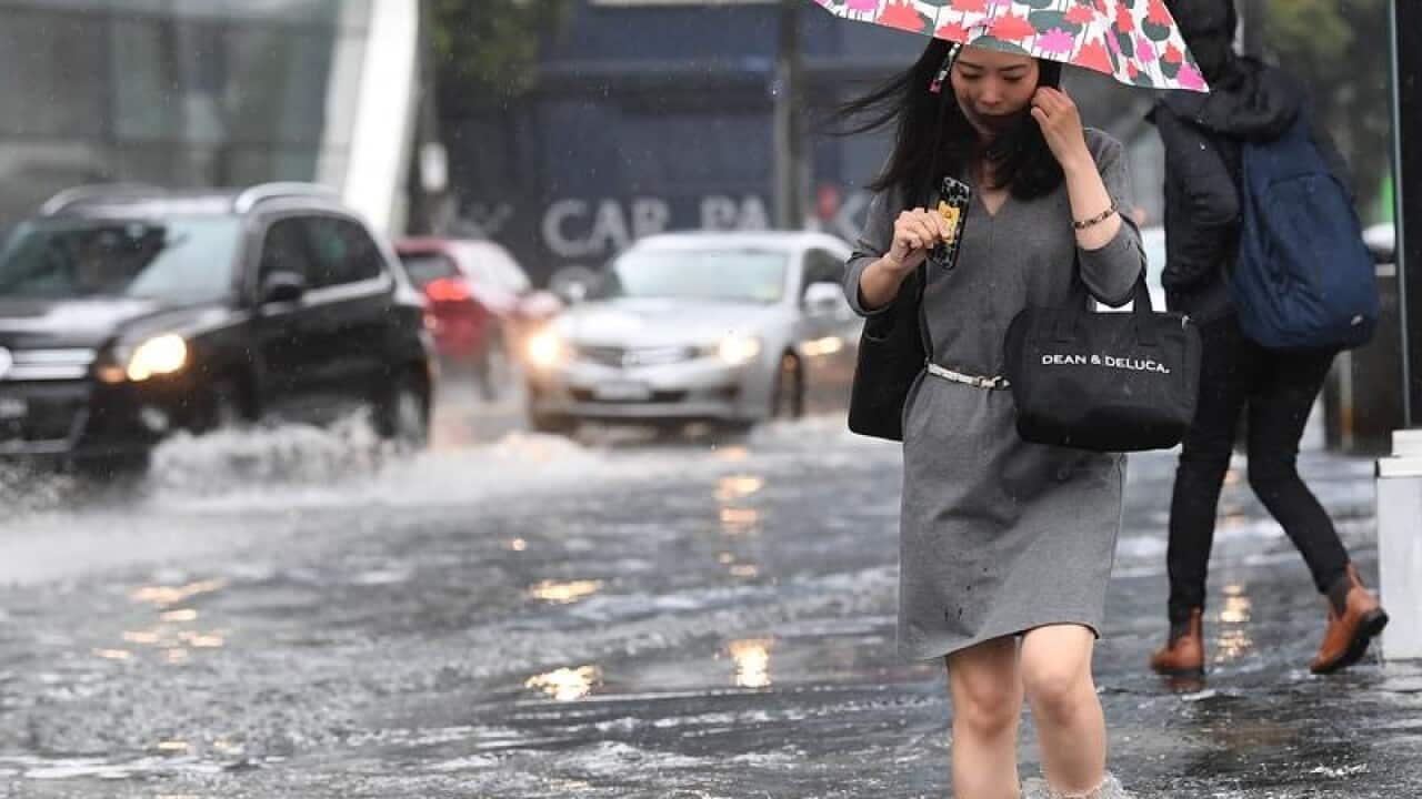 Pedestrians walk through flood waters in South Melbourne.