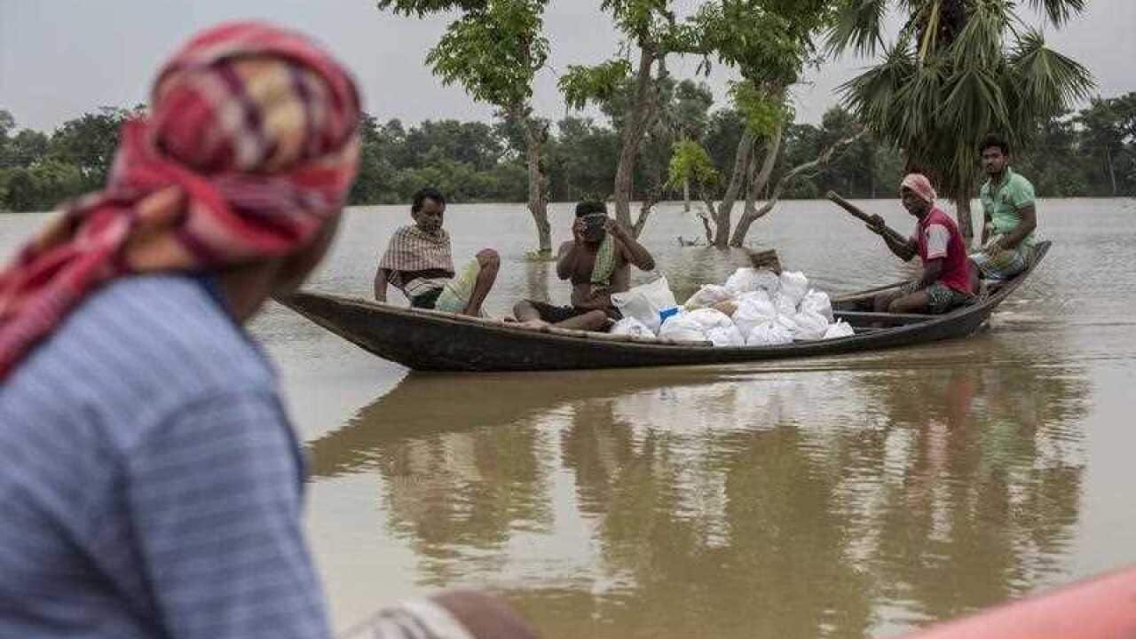 Locals distribute relief meterial for flood victims at flooded Amta village in eastern India.
