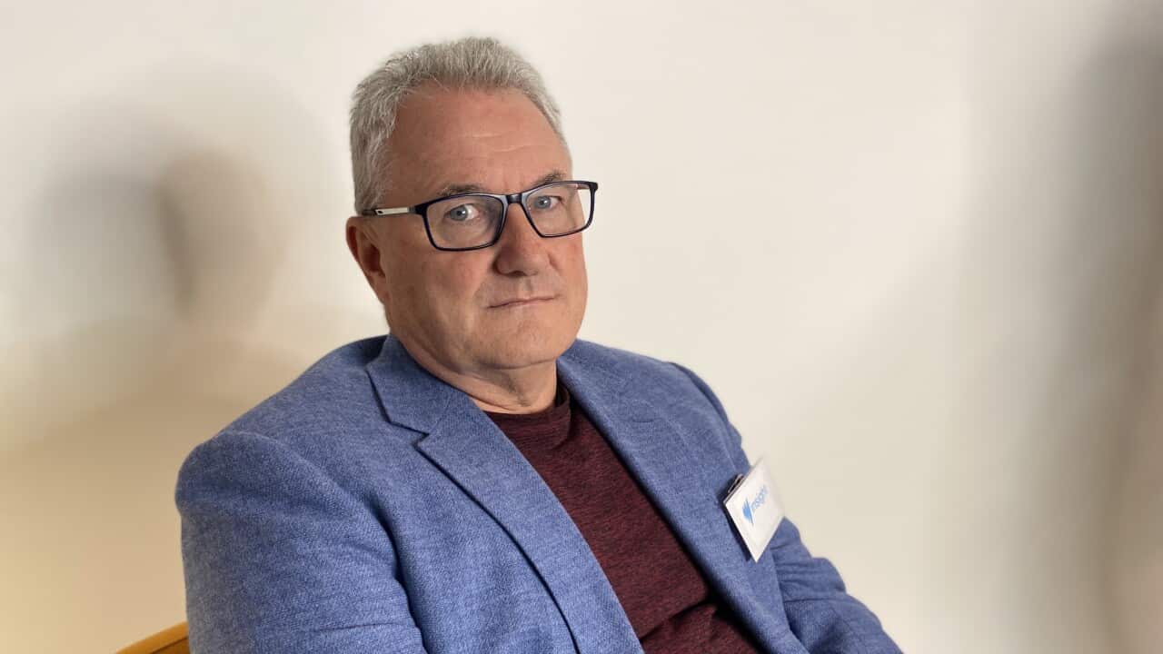 a man wearing glasses and a blue jacket