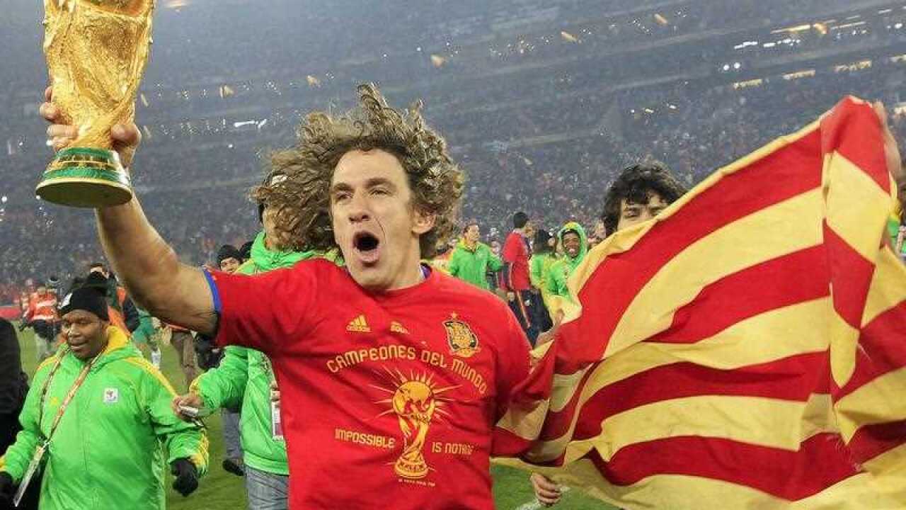 Spain's Carles Puyol celebrates with the World Cup trophy after the FIFA 2010 World Cup final soccer match between the Netherlands and Spain.