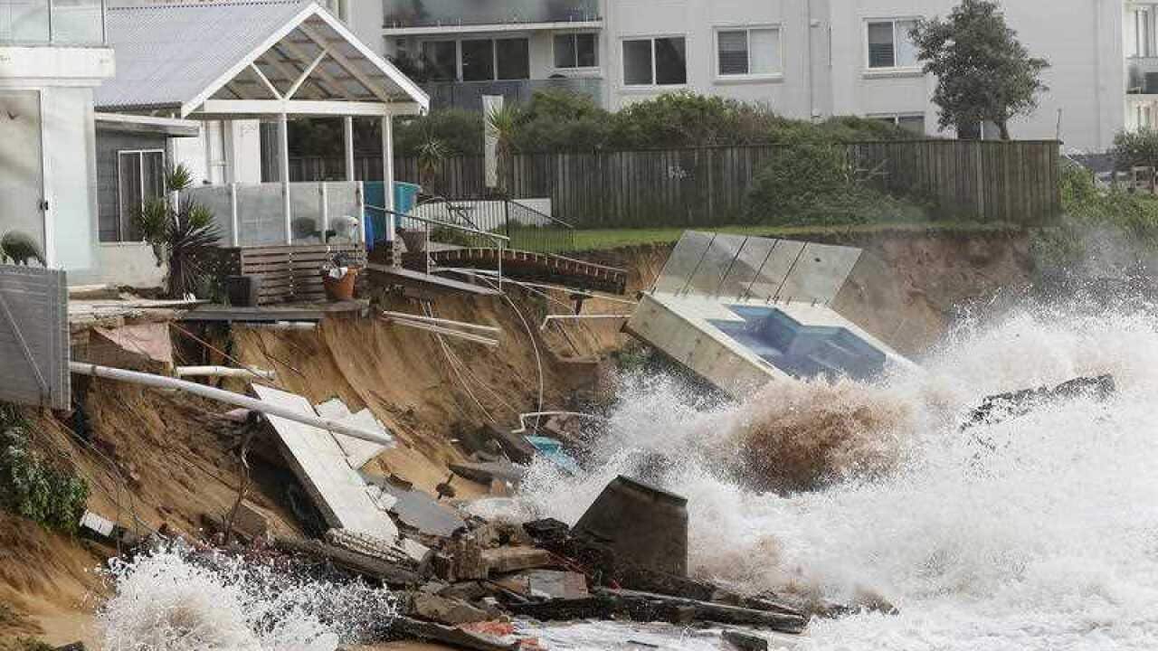 Waves crash against a garden swimming pool that was washed away from a property on the beach front after heavy rain and storms at Collaroy