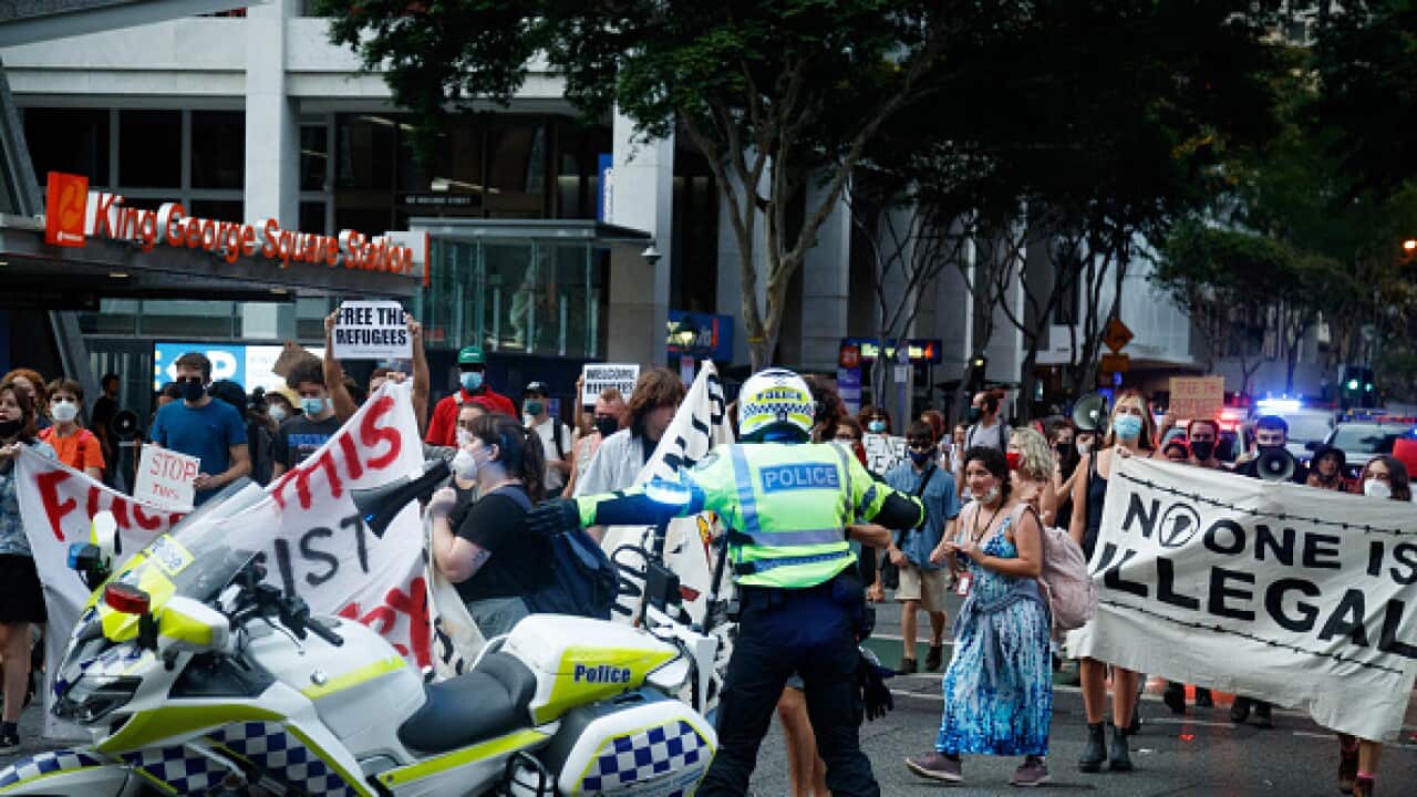 People marching in the street holding banners