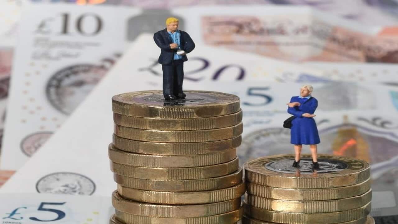 Man on big pile of coins, looking down on woman on smaller pile.