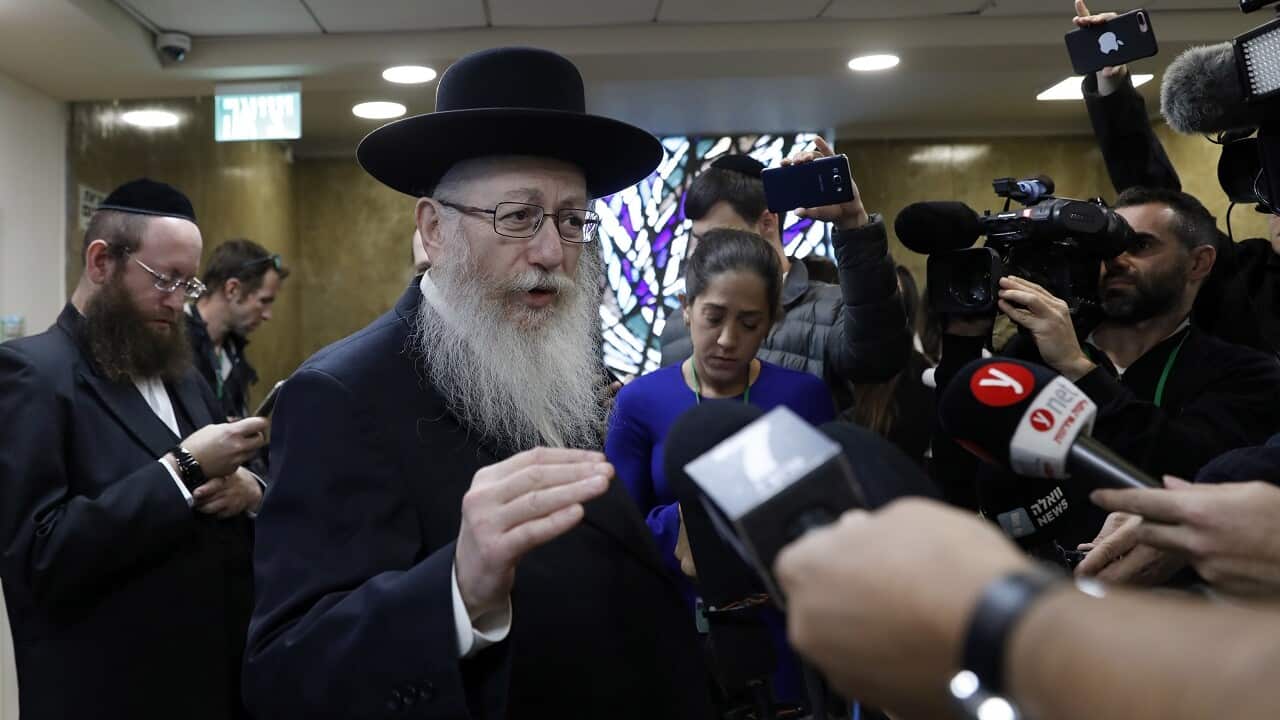 Yaakov Litzman talks to reporters.