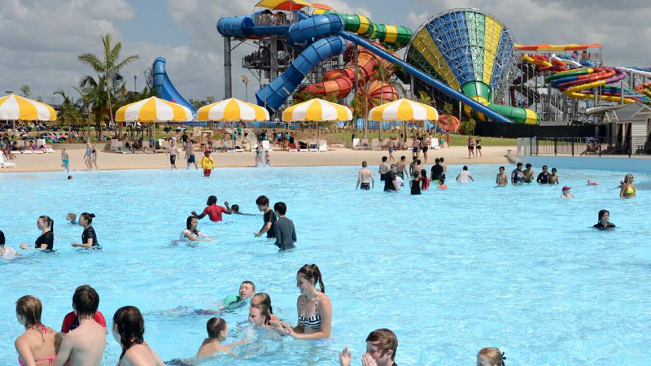 Visitors swim in a pool at Wet N Wild theme park