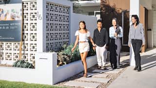 Two women and a child outside a home at a house viewing with a real estate agent
