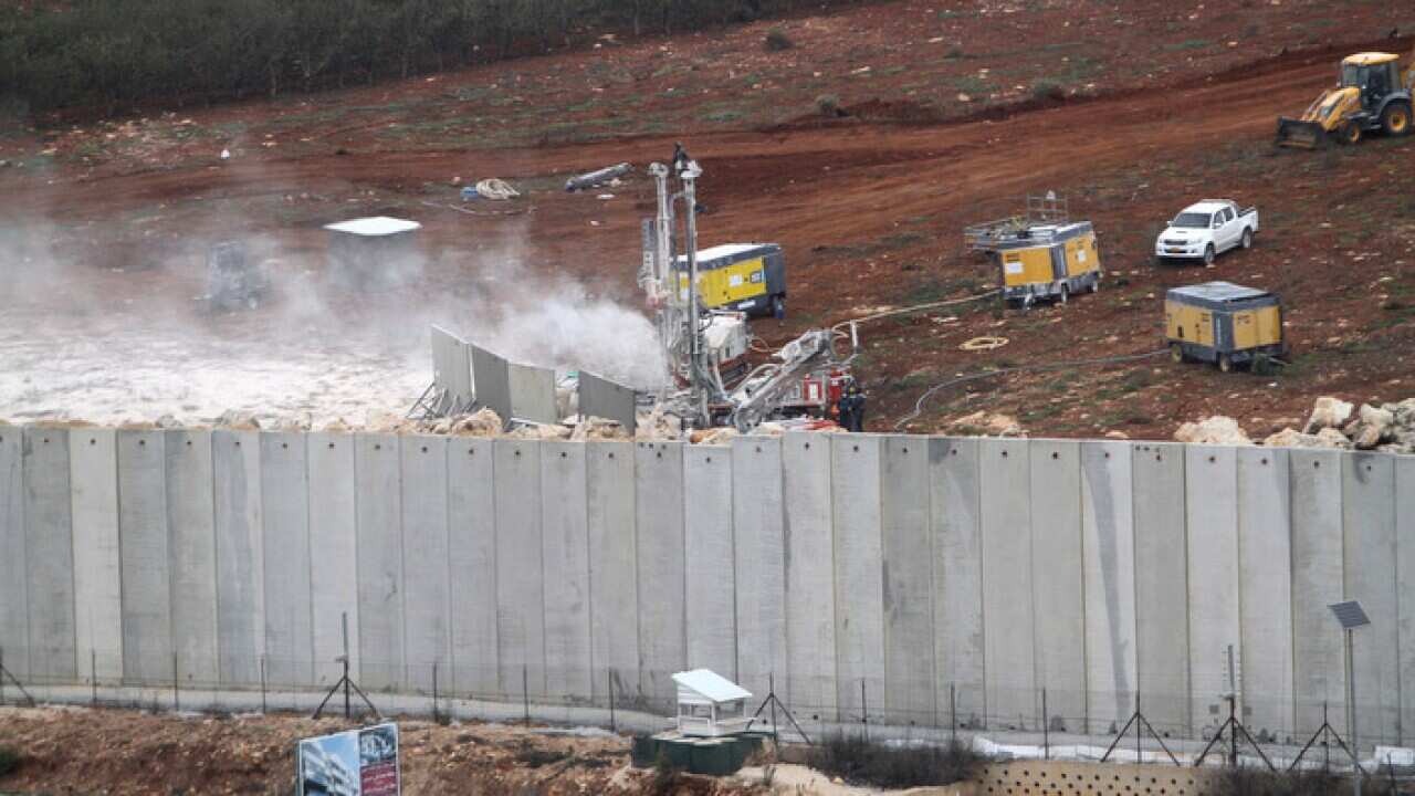 An Israeli military digger works on the Lebanese-Israeli border next to a wall that was built by Israel in the southern village of Kafr Kila.