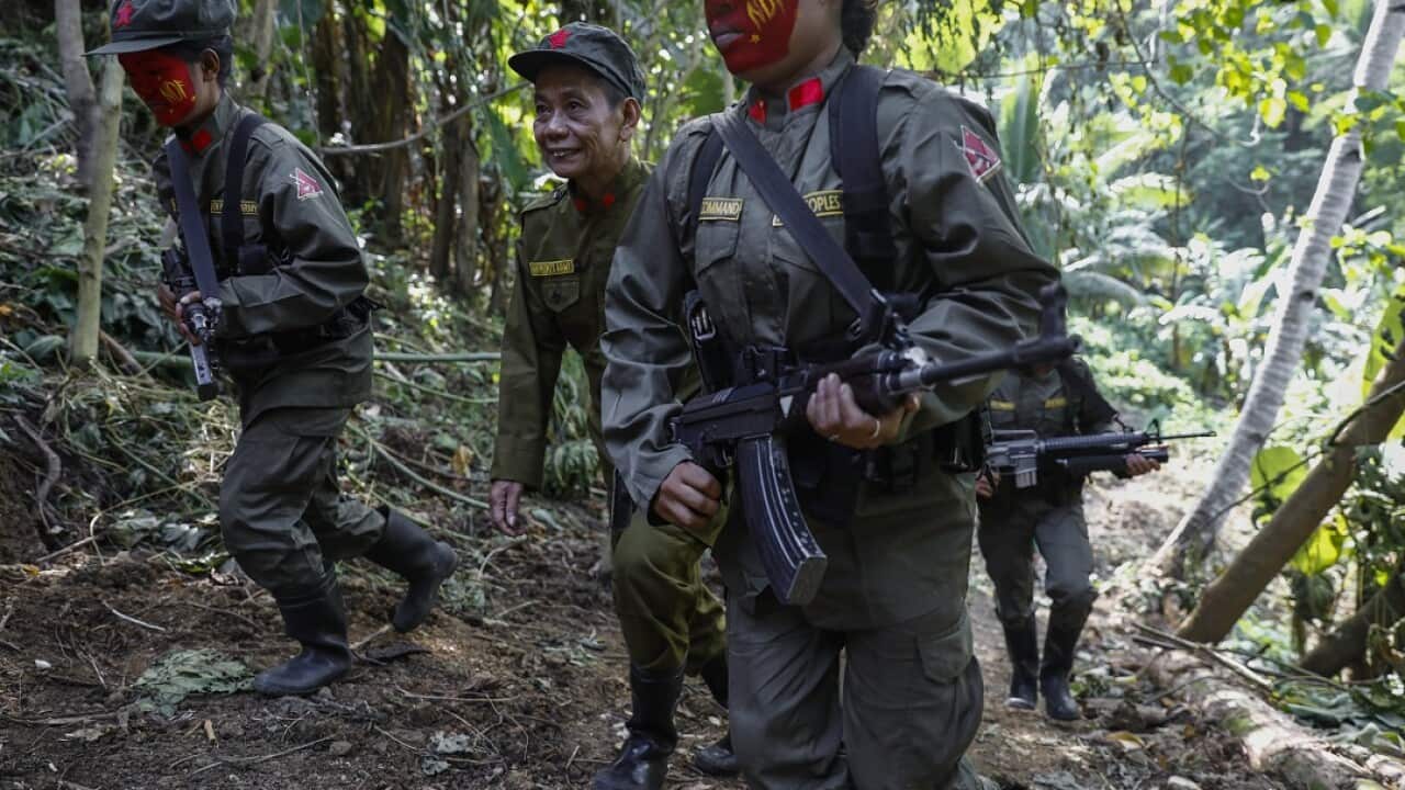 Fighters of the New People's Army walk up a hill with NPA-Melito Glor Command spokesperson Jaime 'Ka Diego' Padilla