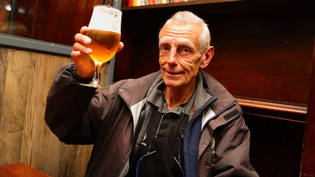 A man rejoices with a pint as pubs open across England.